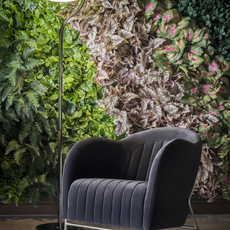 Chaise placée devant un mur végétal artificiel