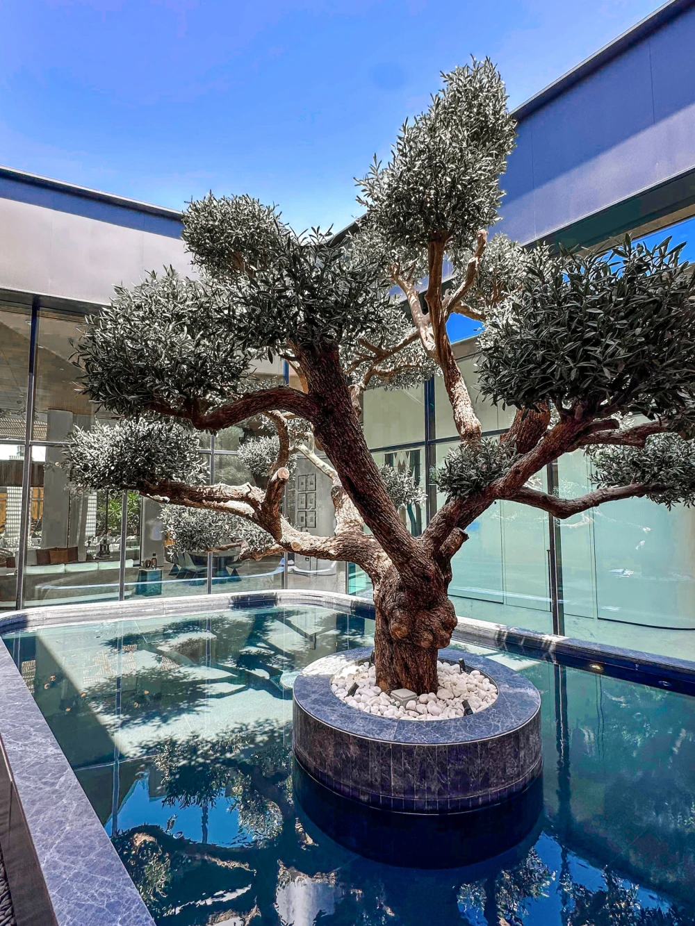 artificial bonsai tree installed outside in a pool